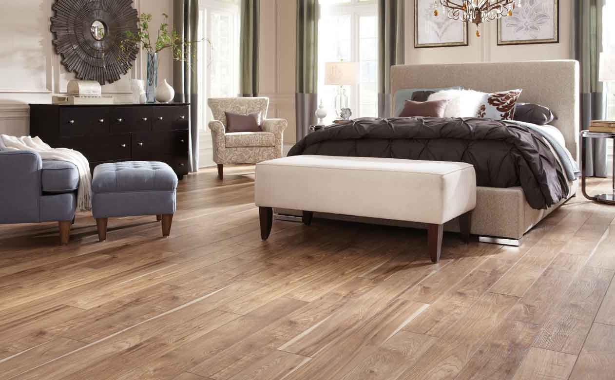 Wide plank wood look tile flooring in bedroom.